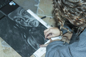 Senior, Audrey Schminger, puts her final touches on her artwork. 