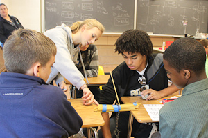 At last years STEM night, AJ Stewart, class of 12, and Heather Kirwan, class of 12, help middle school students perform scientific experiments. This year, STEM night will be held on Tuesday, Oct. 9.
