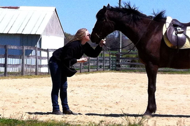 Lazzeri kisses her former race horse Phantom. She rides Phantom in competitions.