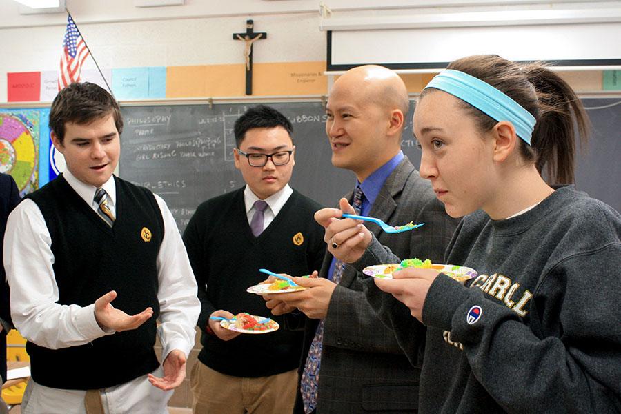 Juniors Nick Lewis and Henry Zhang, AP Physics and religion teacher, Dr. Christopher Yeung, and senior Nina Profili (right to left) celebrate Yeungs new job as Assistant for Seton Vicar. Yeungs advisory threw a goodbye party on Tuesday, Jan. 28, his last full day of teaching at JC.