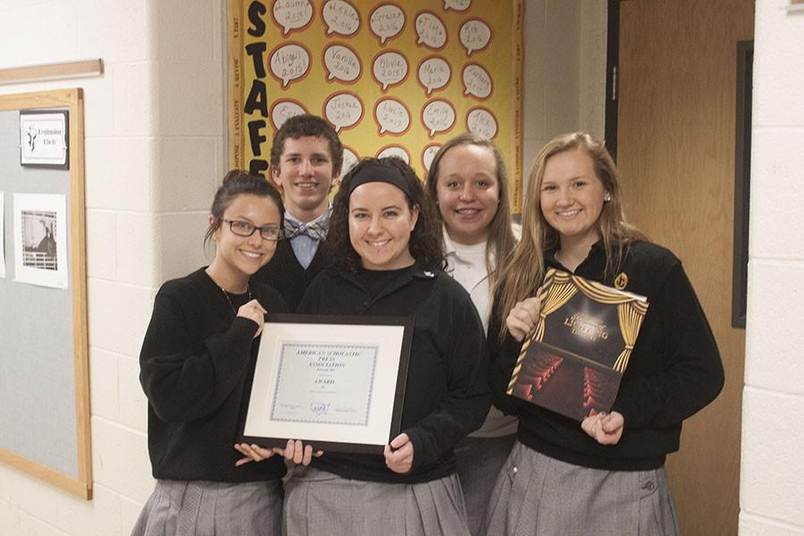 Members of last years yearbook staff pose with one of their awards and the yearbook that won it. This year, the Pacificus won first place again in the American Scholastic Press Associations yearbook competition.