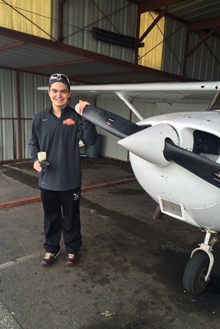 Junior Matt Lozinak poses next to his airplane at the airfield. Lozinak began flying three years ago and balances his time between flying and sports.