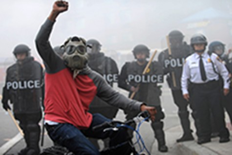 A protester rides his bike in front of a police line at North and Pennsylvania Avenues on Monday, April 27, 2015, in Baltimore. (Algerina Perna/Baltimore Sun/TNS)