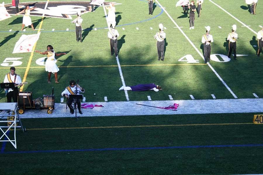 Drum Major Megan Piercy lays still on the field after being killed by senior Color Guard captain Sydney Branch. Piercys death ends the routine and was a source of uneasiness about the performance.