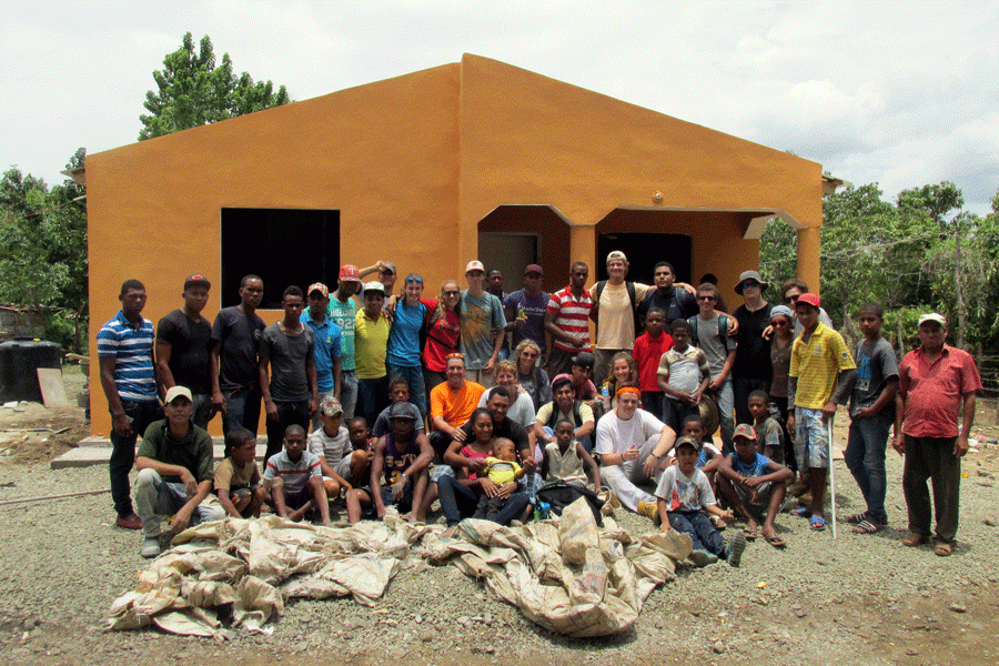 The JC Cambiando Vidas 2015 team and the working group from the Dominican Republic gather for a group a picture after completing the painting of the front of the house. 13 students, religion teacher Thomas Vierheller, and his wife, Donna Vierheller, traveled together to the Dominican Republic to build a house for a family.