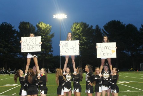 The junior and senior cheerleaders stand in formation at the first home football game under the new lights against St. Pauls. The team helped sophomore and patriot mascot Ashley Schwartz ask her date to homecoming. Cheerleaders are now limited to only sideline performances for football games after the decision to cut their competition routine.