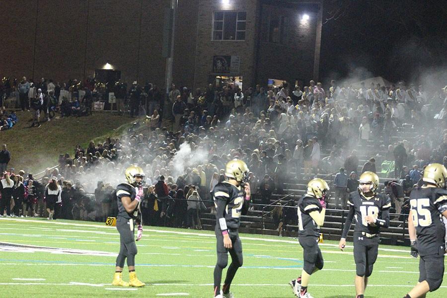 The varsity football teams offense takes the field in front of a cloud of baby powder which arose from the student section. JC won the game  49-14 against St. Marys.