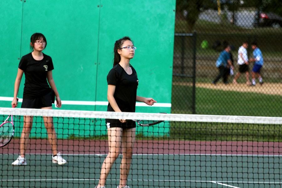 Seniors Vanilla Tong and Lucy Chen prepare for a serve in a doubles match. The varsity womens tennis team finished their season with a 2-4 record.