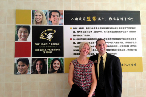 Guidance counselor Larry Hensley and International Student Program Supervisor Sandi Seiler stand proudly in front of a sign advertising The John Carroll School of Shenzhen. The goal is to have the school open in the fall of 2016 where the JC curriculum will be offered to students.