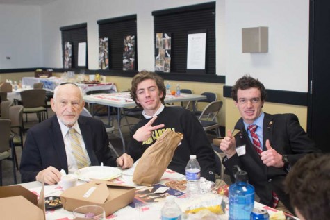 Seniors Matt Becker and Alex Kaufman pose with Holocaust survivor Werner Cohen during the lunch provided for the survivors and their hosts. Senior hosts spent the entire day with one survivor in order to get to know them better.