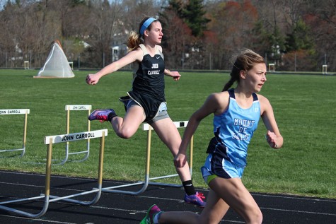 Junior Taylor Brewer leaps over the last hurdle before sprinting towards the finish line of the 200 meter hurdles. John Carroll beat Seton Keough and McDonough but lost to Mount de Sales on  Wednesday April 6.