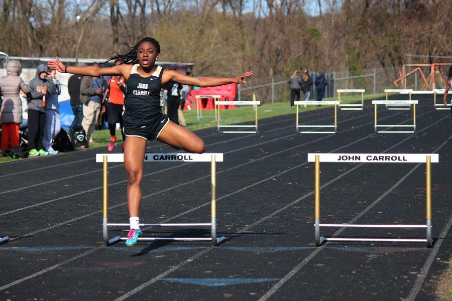 Sophomore Chika Chuku jumps over a hurdle during a race. The womens track team finished with a record of 9-3 and came fourth in the championship.