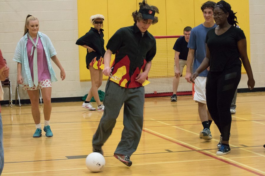 Senior Matt Becker kicks the ball while maneuvering through defense during a game of indoor soccer. All senior Field Day teams played games including soccer, frisbee and dodge ball against each other.