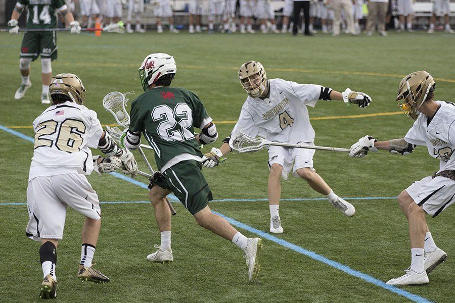 Junior Alex Wroe, sophomore Keiron Leonard, and junior Joe Rayman play defense on a Glenelg player trying to transition the ball down field. The mens lacrosse team payed Glenelg Country School in a championship game on Friday, May 20 at Johns Hopkins - Homewood field.