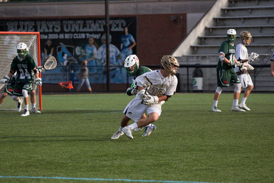 Junior Paul Poholsky spins towards the goal to get an open shot. The mens lacrosse team finished their season with a 19-6 record, capturing the championship.