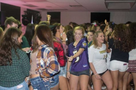 Juniors Katie Mills (left) and Mackenzie Lawry (right) dance with their friends during the Back to School Dance on Sep. 9. The Back to School Dance is held annually in order to encourage students to get excited about the upcoming school year.