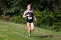 Cross country runner strides by competition