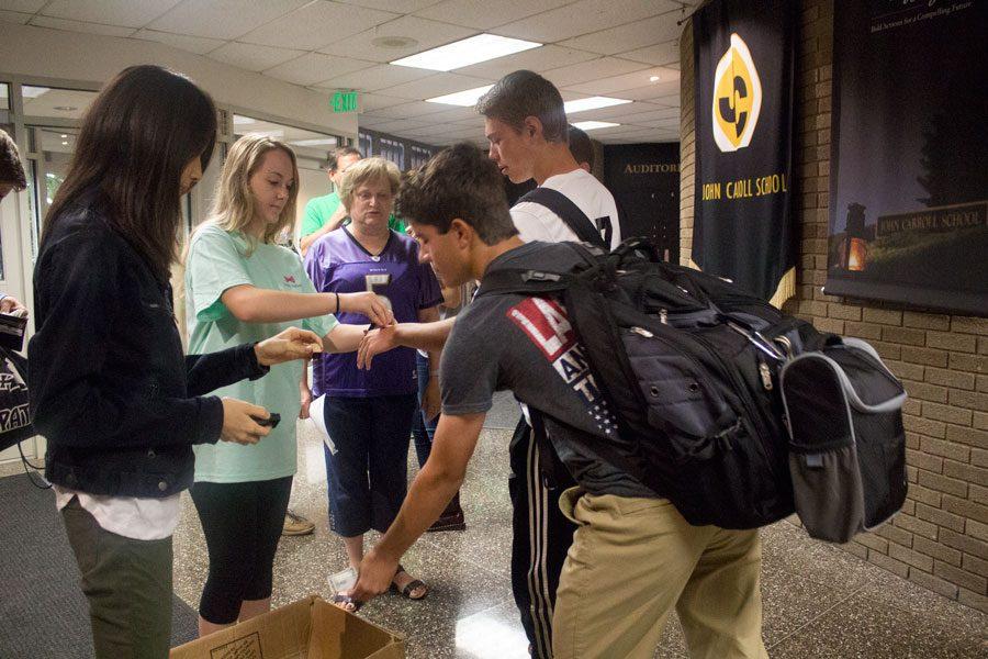 Junior Service Club President Caitlyn Trent stamps students hands showing they donated money to dress down. The Service Club held a dress down day on Sept. 16 to raise money for the Ronald McDonald House, an organization that helps house and fund families whose children have cancer.