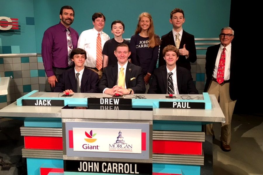Sophomore Jack Plumer, Academic Team captain junior Drew Forthman, and sophomore Paul Capobianco (left to right) pose with the Academic Team moderator Chris Deaver, sophomores Pierce Berger and Ryan Newberry, freshmen Alexis Loder and Leo Hojnowski, and former Russian teacher Edward Miller (left to right back row) at the taping of Its Academic. The team beat Hereford High School and Calvert High School in the first round of the show on the Sept. 24 game.