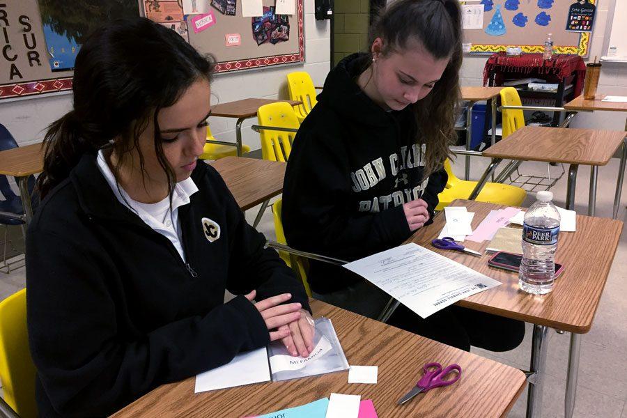 During a Spanish Club meeting, sophomores Emily Fitzpatrick and Caitlin Kerrigan (left to right) make Me books for the seniors to take on their trip to Honduras in the spring. The books, which consist of different pictures of the seniors life, will be given to the children they meet in Honduras as a gift.