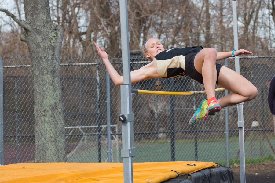 Junior Ashlee Kothenbeutel jumps over the bar with height to spare in the high jump. Kothenbeutel tied for second place with a height of 410 at the IAAM A Conference home meet on Wednesday, April 5.