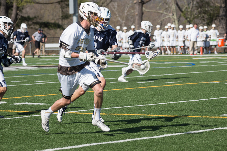 Senior Joe Rayman out-runs one of Gilmans defenders in a home game. The mens lacrosse team played against Gilman, an A-Conference team, on Tuesday, April 11 and lost the game with a score of 7-8.
