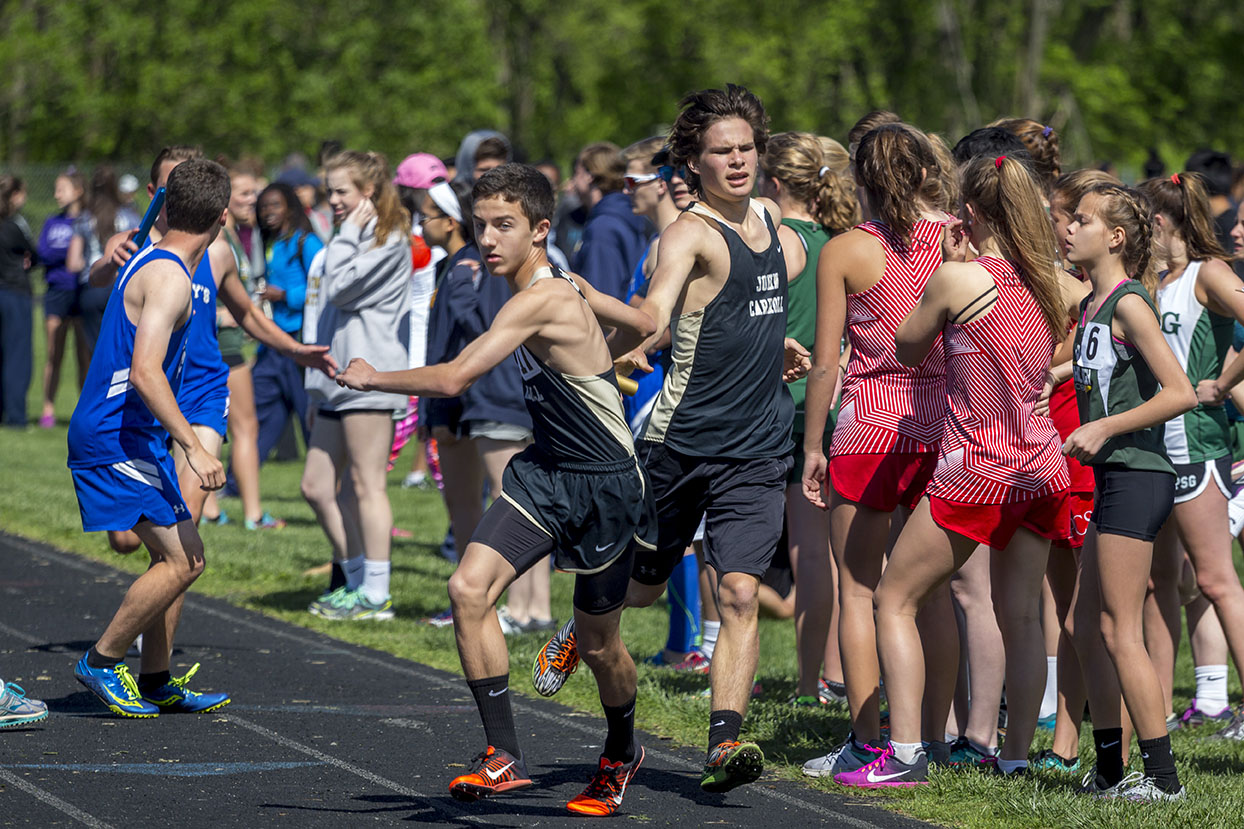 Sophomore Wyatt Moran grabs the baton from junior Jared Vogel during the third leg of the 4x800 meter relay at the MIAA and IAAM B Conference Championship. JC hosted the championship on Wednesday, May 3, and the varsity mens outdoor track team placed second to Saint Vincent Pallotti. 
