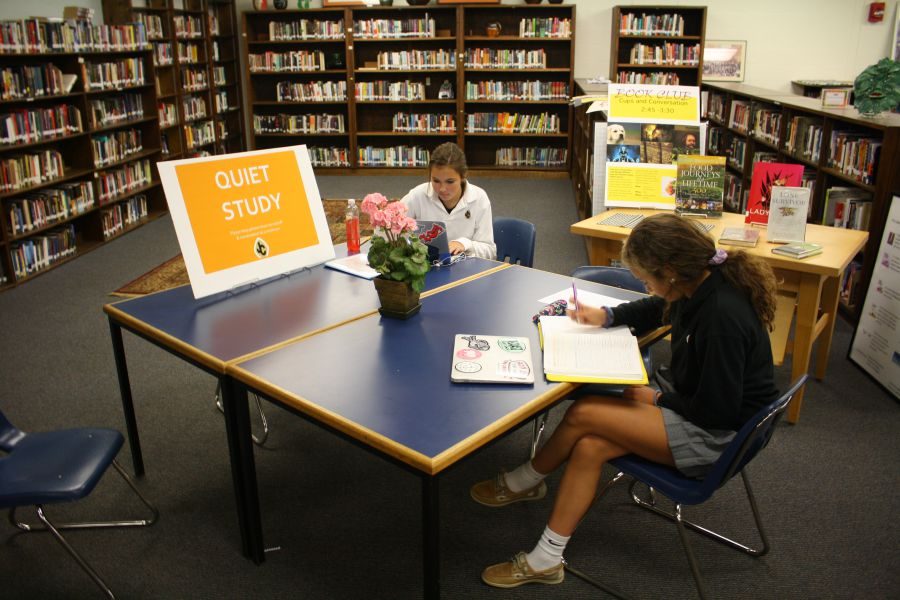 Sophomores Mackenzie Walton (left) and Ryleigh Casserly (right) finish school work in the new quiet Media Center. The silent policy was enacted this year by Principal Tom Durkin and has received mixed reviews from students.