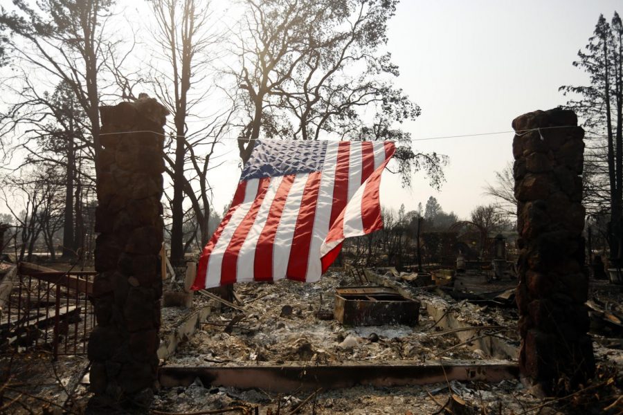 A U.S. flag hangs from the remnants of a fire-ravaged home on Willowview Court in the Coffee Park neighborhood of Santa Rosa, Calif. on Wednesday, Oct. 18, 2017. 

