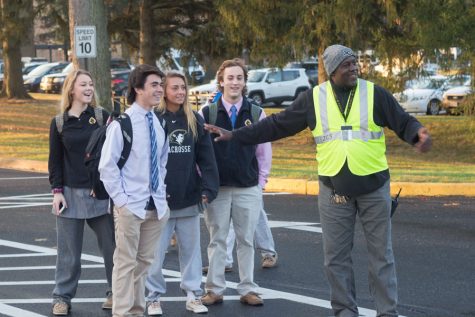 Member of the Facilities Management Department John Wilkie directs juniors Taylor Umbarger, Kiersten Euler, Jordan Remeto, and senior Auggie Van Dalsum on their walk from the student lot to school on the morning of Friday, Dec 1. The crossing guard is just one solution to many problems that remain. 